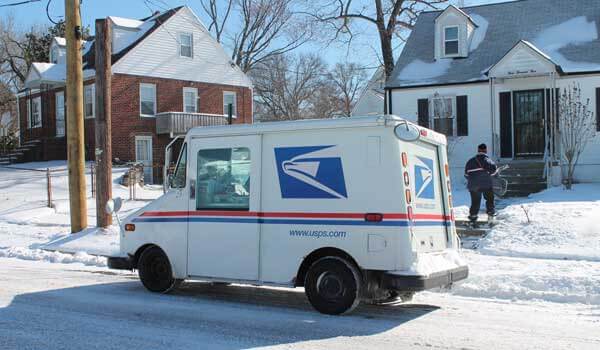 Mail carrier and mail truck in winter
